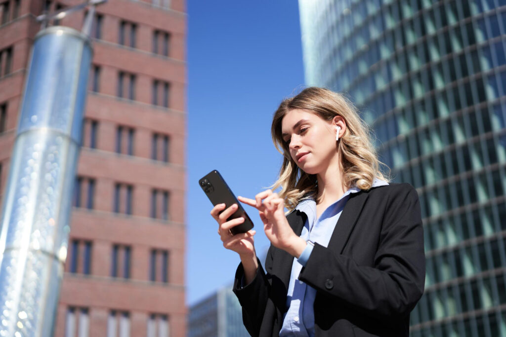 Persoană tânără lucrând de pe telefon într-un mediu modern